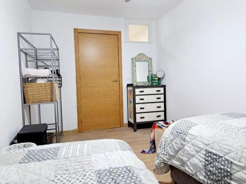 - une chambre avec 2 lits, un miroir et une commode dans l'établissement Casa de los Suenos Granada, 