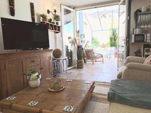 een woonkamer met een tv en een houten salontafel bij Casa de los Suenos Granada 