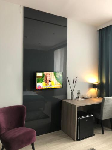 a living room with a tv on a wall at Pensiunea Lido in Piatra Neamţ