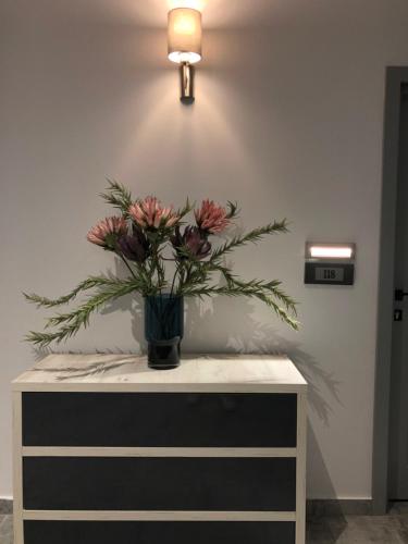 a vase of flowers sitting on top of a dresser at Pensiunea Lido in Piatra Neamţ