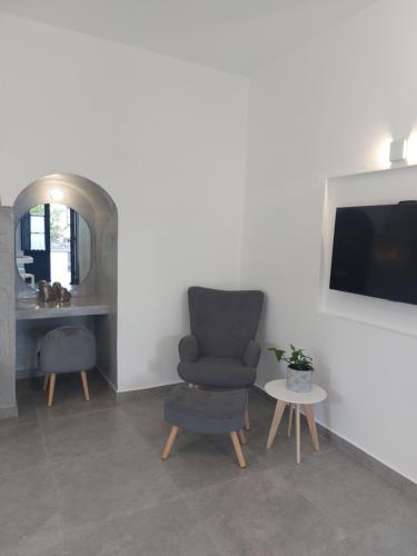 a living room with a chair and a table at Anthonas Apartments in Imerovigli
