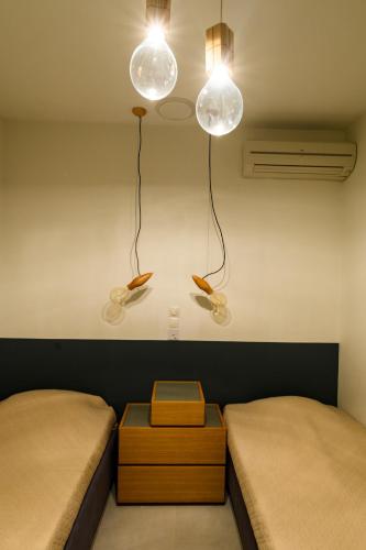 a room with two beds and two lights on the wall at Athens riviera beach villa in Anavissos