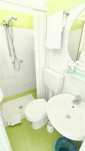 a white bathroom with a toilet and a sink at Hotel Casa Nicola in Ischia