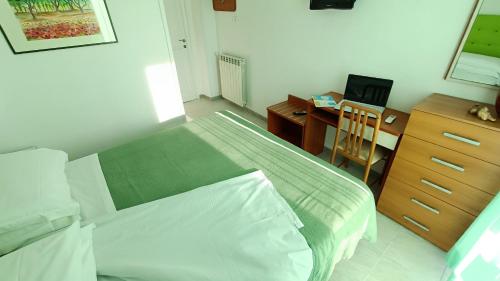 a bedroom with a bed and a desk with a computer at Hotel Casa Nicola in Ischia
