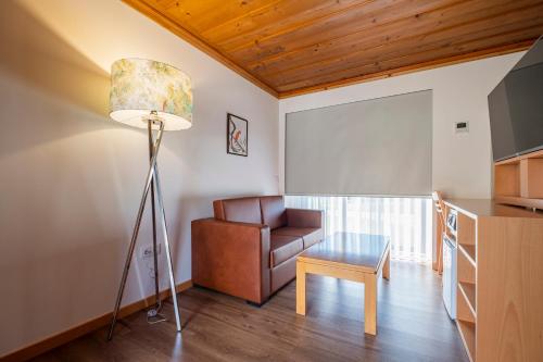 a living room with a couch and a lamp and a chair at Casa de Fervença in Espesês