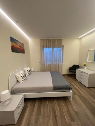 een slaapkamer met een bed, een bureau en een raam bij Appartamento Lago in Ponte Caffaro