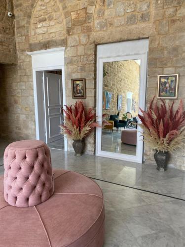 a living room with a pink ottoman in the middle at Dar Alice in Soûr