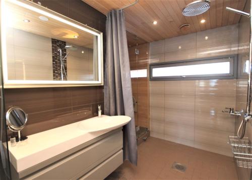 ein Bad mit einem Waschbecken und einer Dusche in der Unterkunft Gella Serviced Apartments Office in Helsinki
