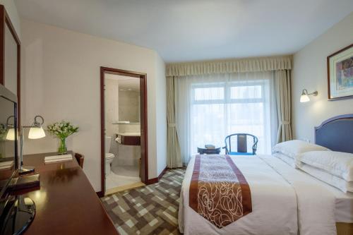 a hotel room with a large bed and a bathroom at Beijing Landmark Towers in Beijing