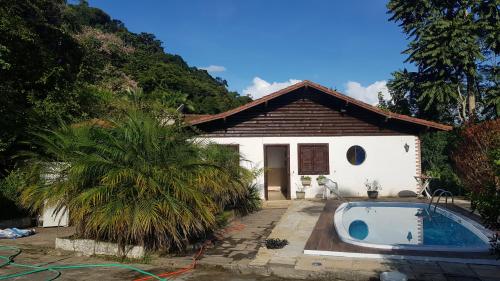 uma casa com uma piscina em frente em Vale das Maritacas Teresópolis em Teresópolis