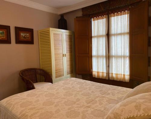 a bedroom with a bed and a window and aoir at La Llosa de Sámano in Castro-Urdiales