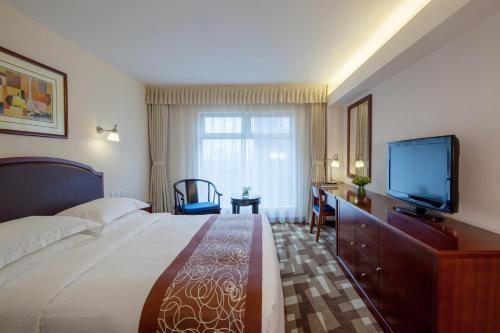 a hotel room with a bed and a flat screen tv at Beijing Landmark Towers in Beijing