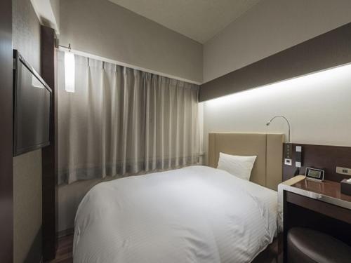 Postel nebo postele na pokoji v ubytování Nagoya Kanayama Hotel
