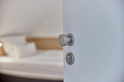 a white door with a silver door knob at Moselhotel Weinhaus Simon `Sauna`Restaurant`ELadesäule in Wintrich