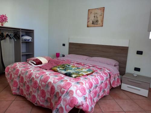una camera da letto con un grande letto e un piumone rosa di 4 giugno Ferrara a Ferrara