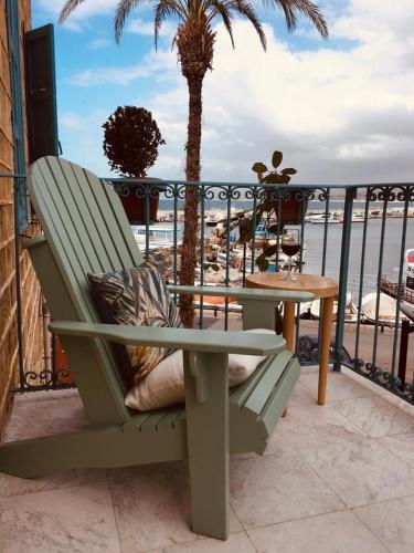 a green chair sitting on a balcony with a table at Dar Alice in Soûr