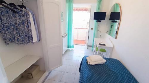 a small room with a bed and a table and a window at Hotel Casa Nicola in Ischia