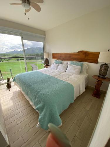 a bedroom with a large bed and a large window at Playa Caracol Chame in Chame