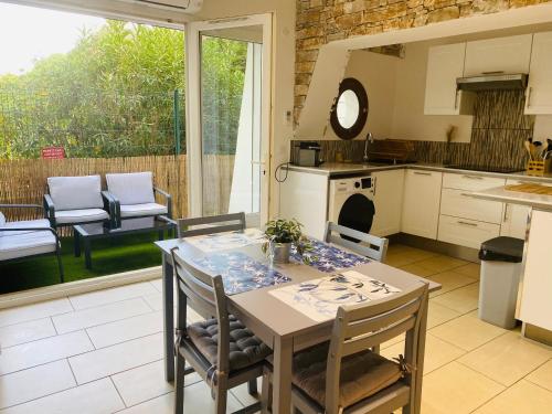 uma cozinha e sala de jantar com mesa e cadeiras em Magnifique T2 en bord de mer em Le Lavandou