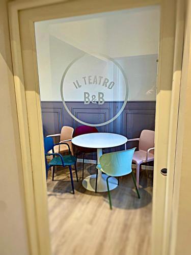 a table and chairs in a room with a sign at Il Teatro in Acquapendente