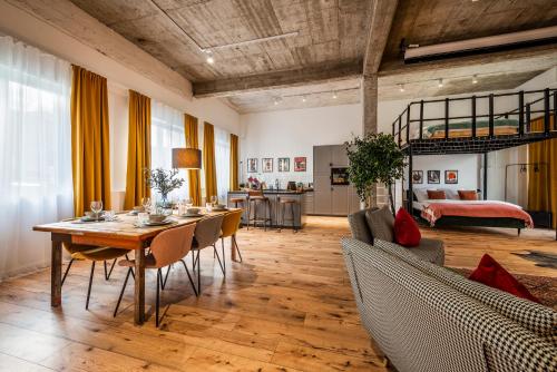 a living room with a table and chairs and a bed at Klassen Stay - Exklusives Loft - XXL Leinwand - 4 km Messe, 1,5 km HBF in Essen