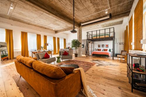 ein großes Wohnzimmer mit einem Sofa und einem Tisch in der Unterkunft Klassen Stay - Exklusives Loft - XXL Leinwand - 4 km Messe, 1,5 km HBF in Essen