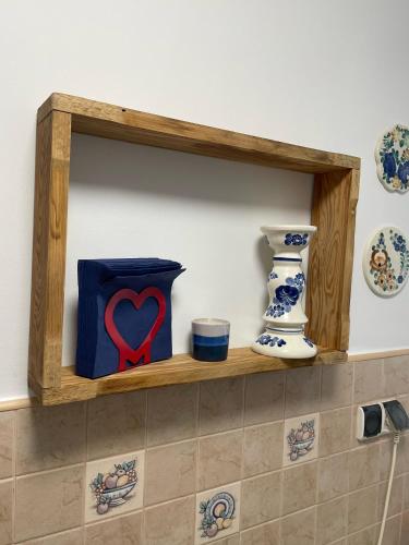 a wooden shelf with a heart decoration on a wall at Apartament Dobre Miejsce in Malbork