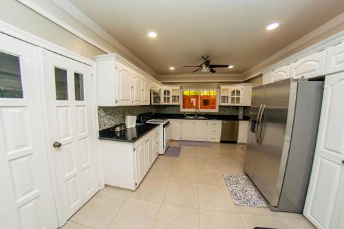 a kitchen with white cabinets and a stainless steel refrigerator at JR Apartments in Georgetown