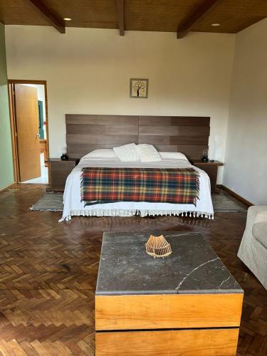 a bedroom with a large bed with a wooden headboard at Rancho Emisajumi El Ajusco in Mexico City