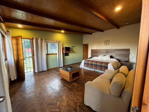 a bedroom with a bed and a couch in a room at Rancho Emisajumi El Ajusco in Mexico City