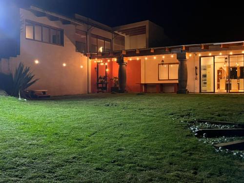 a house with a yard at night with lights at Rancho Emisajumi El Ajusco in Mexico City