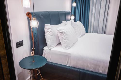 a bedroom with a bed with a blue headboard and a table at Giardino Lux Apartments in Ulcinj