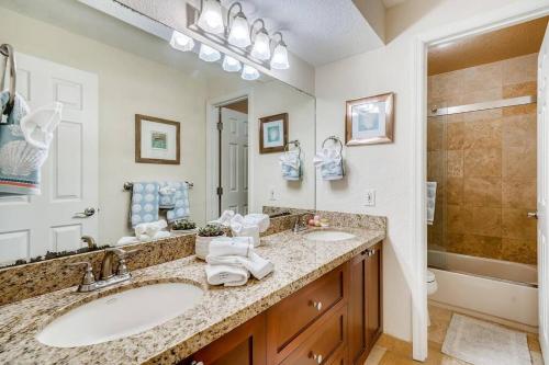 a bathroom with two sinks and a large mirror at Beach 2 level spacious condo in Fort Lauderdale