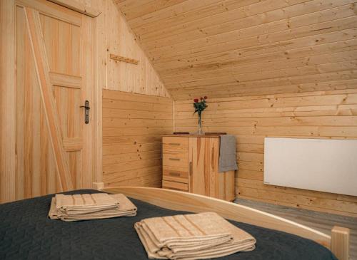 a bedroom with a bed in a wooden room at Górskie Chatki Krysi i Piotrka Perłowy in Stronie Śląskie