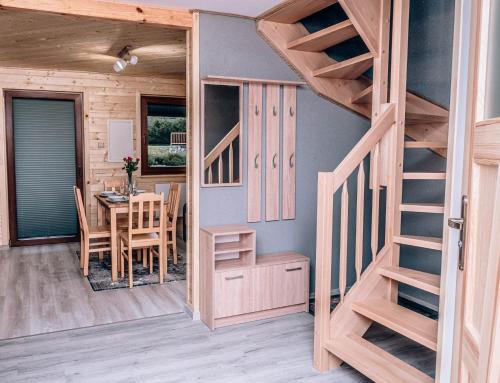 a room with a bunk bed and a dining room with a table at Górskie Chatki Krysi i Piotrka Perłowy in Stronie Śląskie