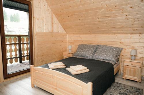 a bedroom with a bed in a wooden cabin at Górskie Chatki Krysi i Piotrka in Stronie Śląskie
