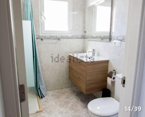 ein Badezimmer mit einem WC, einem Waschbecken und einem Spiegel in der Unterkunft BELLAVISTA 9 in Oliva