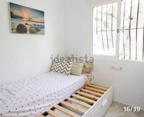 Bett in einem weißen Zimmer mit Fenster in der Unterkunft BELLAVISTA 9 in Oliva
