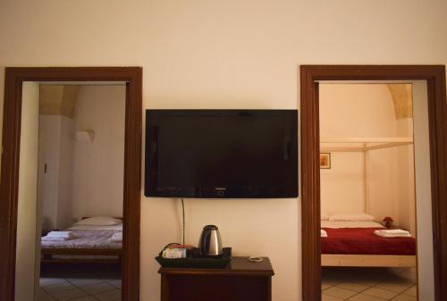 TV de pantalla plana en la pared de una habitación en La Cecia - Casa vacanze nella campagna salentina, en Cavallino di Lecce