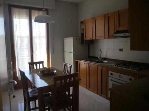 a kitchen with a table and chairs and a kitchen with a refrigerator at Domus Tilla in Piombino