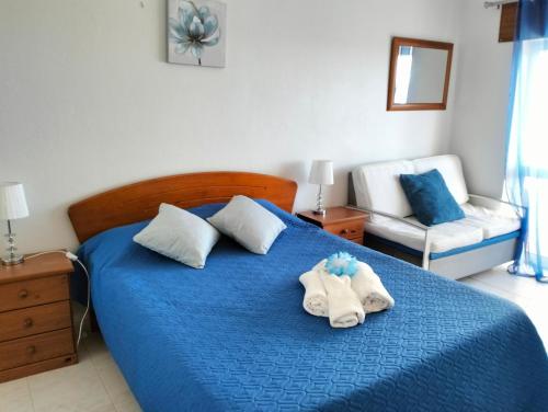 - une chambre avec un lit bleu et des serviettes dans l'établissement 5F Estrela - Casas & Papeis, à Armação de Pêra