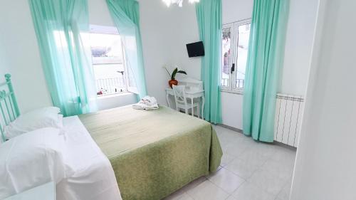 a bedroom with a bed and a table and a window at Hotel Casa Nicola in Ischia