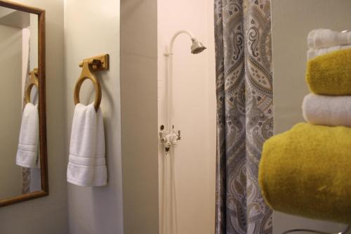 ein Badezimmer mit einem Spiegel und einer Dusche mit Handtüchern in der Unterkunft The Bonnie Inn Unit 1 in San Andreas