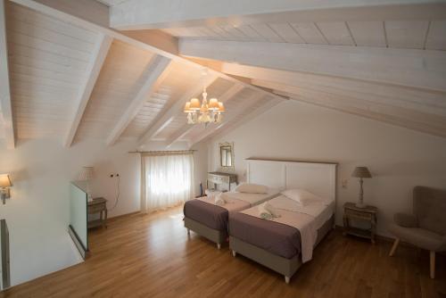 a large bedroom with a bed and a chandelier at Kampos Apartment in Vasiliki