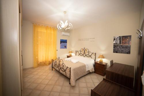 a bedroom with a bed and a chandelier at B&B La Terrazza Degli Scrittori in Racalmuto
