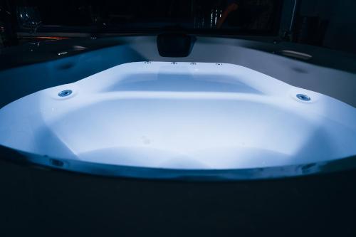 a white bathtub in a dark room at LA PIANTA - Uma experiência na Villa de Monte Verde in Monte Verde