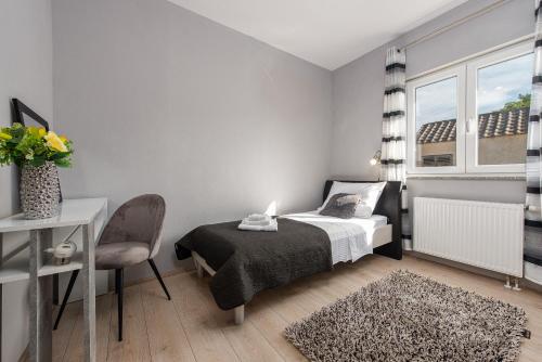 a bedroom with a bed and a chair and a window at Holiday house Karla in Zadar