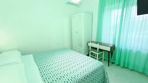 a small bedroom with a bed and a desk at Hotel Casa Nicola in Ischia