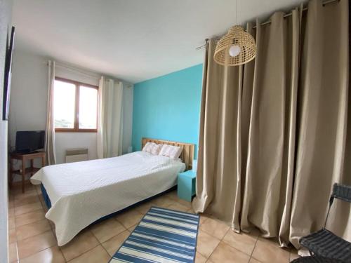 ein Schlafzimmer mit einem Bett und einer blauen Wand in der Unterkunft small house 6p in bormes, quiet , hill-view in Bormes-les-Mimosas