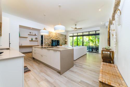 an open kitchen with white cabinets and wood floors at Blue Residences- Ground floor two bedroom apartment in Grand Baie